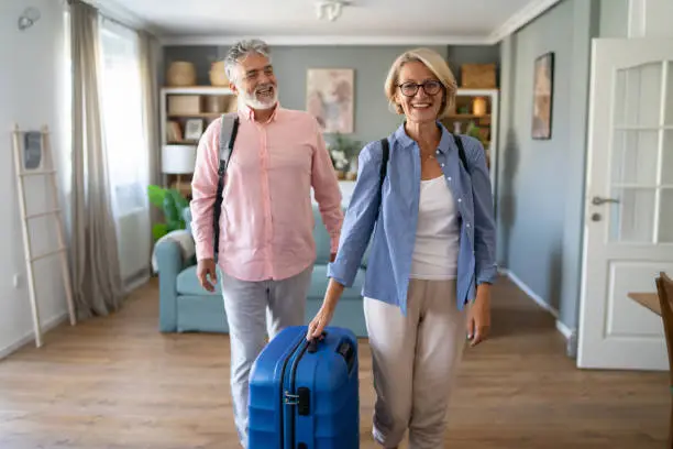 managing the probate process for texas vacation homes, senior couple standing with suitcase about to leave for vacation