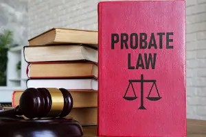 Red book titled "PROBATE LAW" with a scale of justice symbol, placed next to stacked legal books and a gavel, representing legal services related to estate planning and probate law in Dallas, Texas.