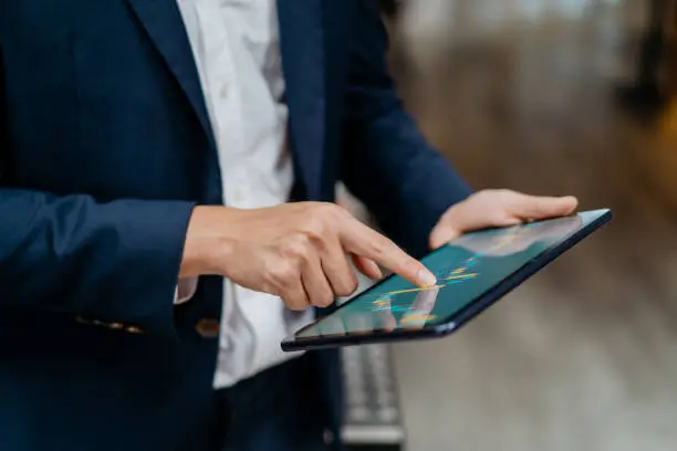 the digital revolution has drastically reshaped how people store and manage their wealth, asian businessman checking stock market chart on digital tablet