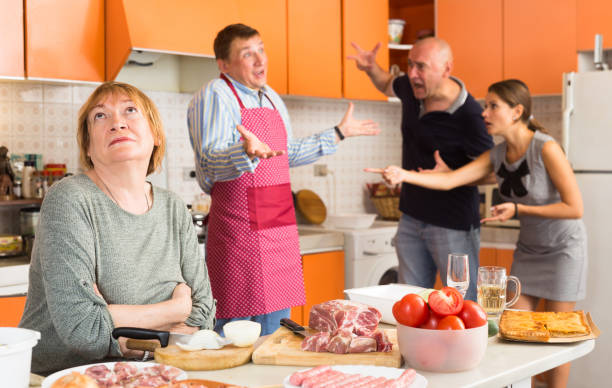 Family members arguing in a kitchen while preparing dinner, with visible frustration and disagreement over shared responsibilities related to inherited property.