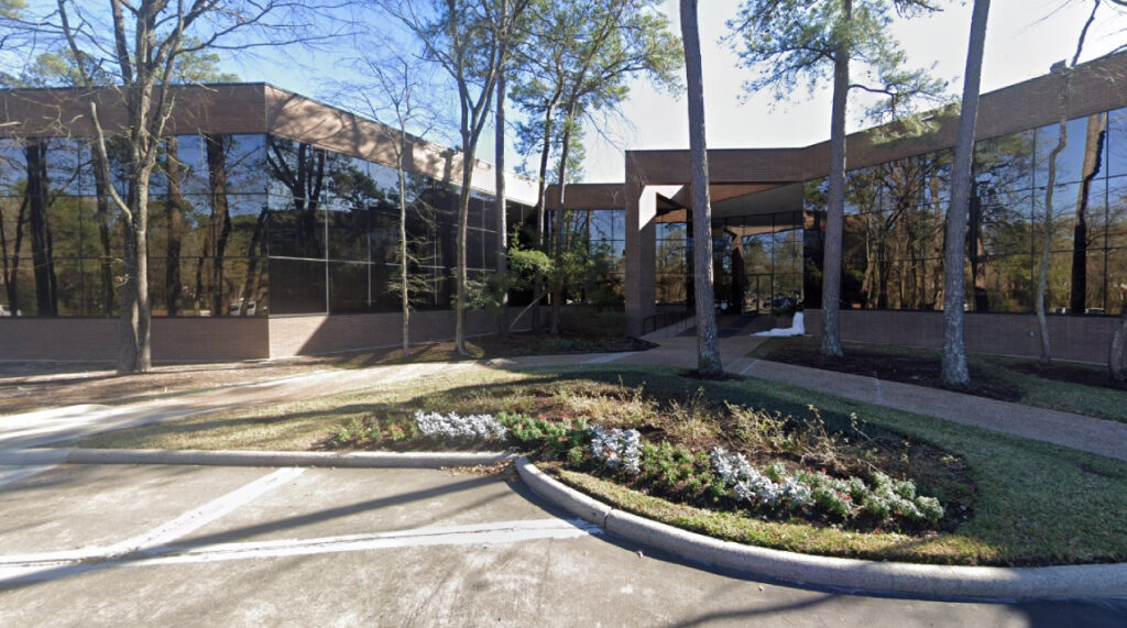 Modern glass building exterior of Bryan Fagan Law Office in Kingwood, Texas, surrounded by trees and landscaping, emphasizing a professional yet inviting atmosphere.